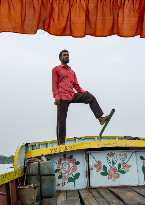 Bangladeshi man rowing a boat with his foot in Sundarbans, Barisal Division, Banaripara, Bangladesh