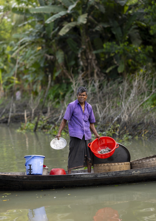 Bangladeshi man on a local boat fishing shrimps on a river, Barisal Division, Banaripara, Bangladesh