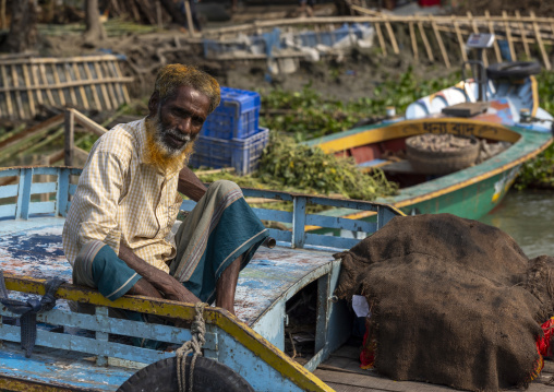 Bangladeshi man selling fruits and vegetables at weekly floating market, Barisal Division, Harta, Bangladesh