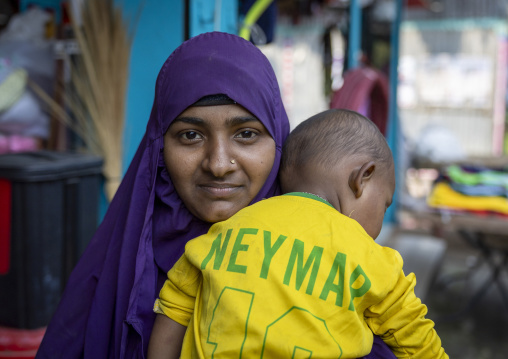 Bangladeshi mother with her child wearing a Neymar brazil football shirt, Barisal Division, Harta, Bangladesh