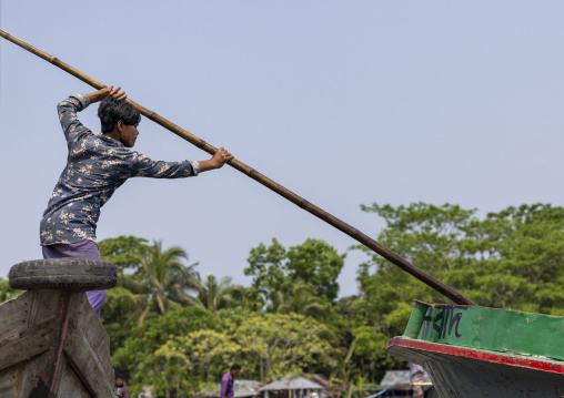 Bangladeshi man pushing a boat with a long stick in Sundarbans, Barisal Division, Wazirpur, Bangladesh