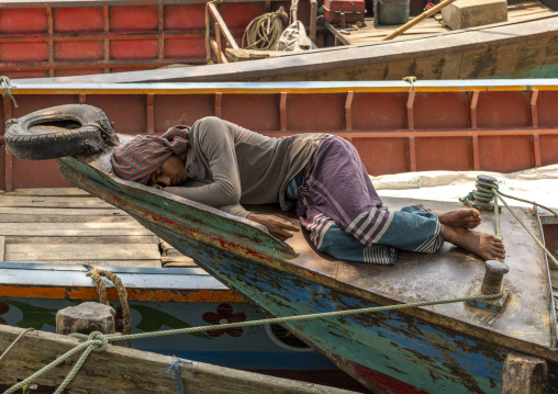 Bangladeshi fisherman sleeping on his boat bow in Sundarbans, Barisal Division, Wazirpur, Bangladesh