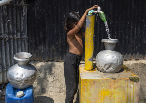 Bangladeshi girl collecting water from pump in Sundarbans, Khulna Division, Shyamnagar, Bangladesh