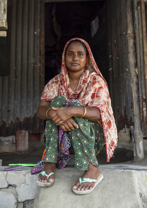 Portrait of a veiled woman sit at the entrance of her house, Khulna Division, Shyamnagar, Bangladesh