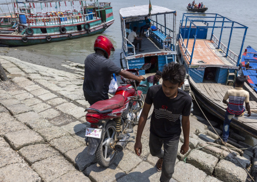 Bangladeshi man loading his motorbike on a boat in Sundarbans, Khulna Division, Shyamnagar, Bangladesh