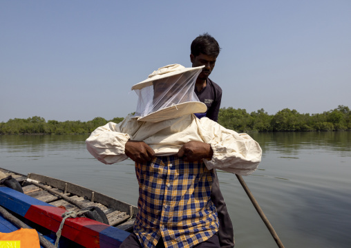 Beekeepers putting protective workwear to collect honey in the mangrove, Khulna Division, Shyamnagar, Bangladesh