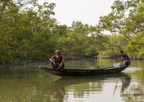 Bangladeshi men on a canoe in the mangrove in the Sundarbans, Khulna Division, Shyamnagar, Bangladesh