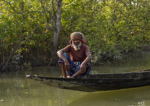 Bangladeshi man in a canoe in the Sundarbans mangrove, Khulna Division, Shyamnagar, Bangladesh