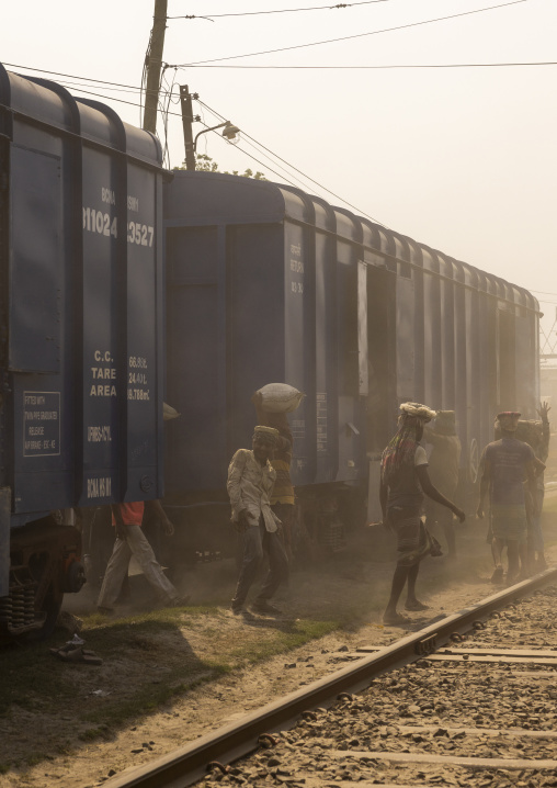 Bangladeshi workers unloading cement bags from a train in the dust, Khulna Division, Abhaynagar, Bangladesh