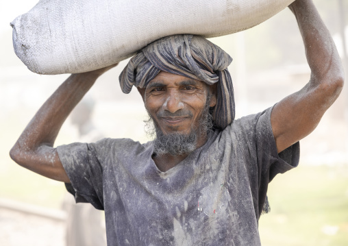 Bangladeshi porter carrying cement bag, Khulna Division, Abhaynagar, Bangladesh