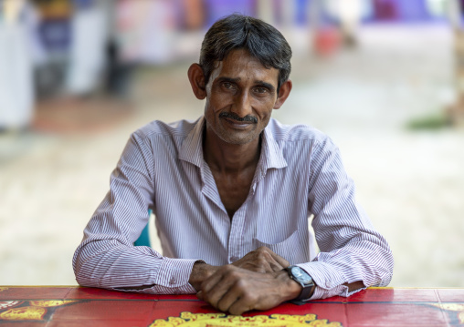 Portrait of a bangladeshi man sit at a table, Khulna Division, Jessore, Bangladesh