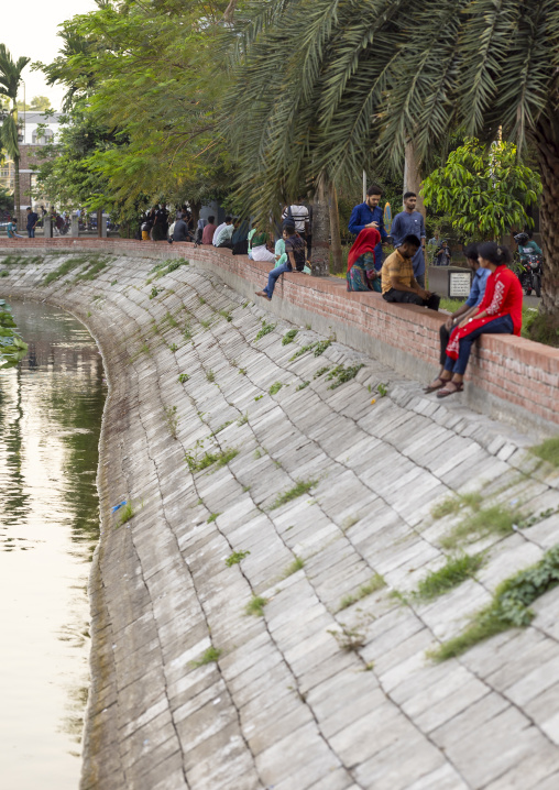 Bangladeshi people sit around a pond, Khulna Division, Jessore, Bangladesh