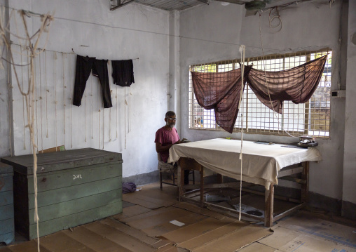 Bangladeshi man reading a book in a silk factory workshop, Rajshahi Division, Rajshahi, Bangladesh