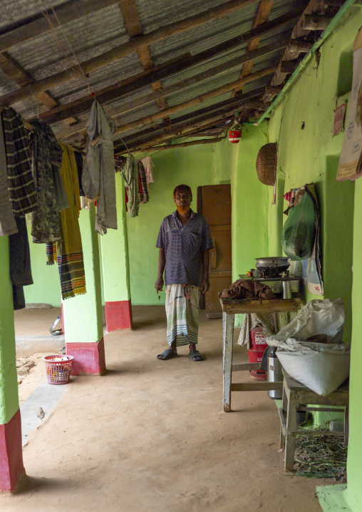 Bangladeshi man standing in the veranda of a green house, Rajshahi Division, Manda, Bangladesh