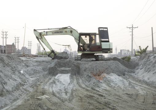 Excavator putting cement on trucks in Amin bazar, Dhaka Division, Sabhar, Bangladesh