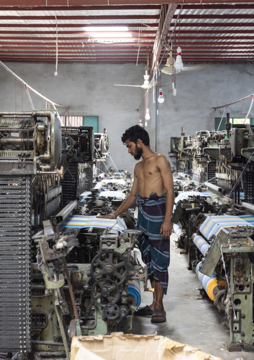 Bangladeshi man working in a extile factory looms, Dhaka Division, Rupganj, Bangladesh