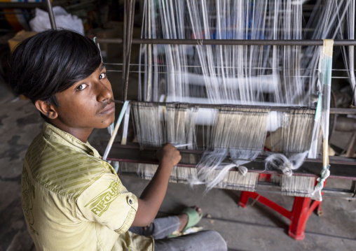 Young bangladeshi man working in a extile factory looms, Dhaka Division, Rupganj, Bangladesh