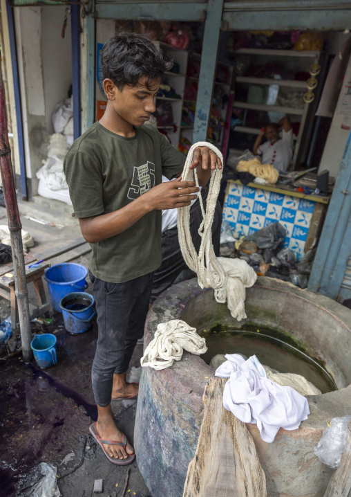 Bangladeshi young man dyeing fabrics, Dhaka Division, Rupganj, Bangladesh