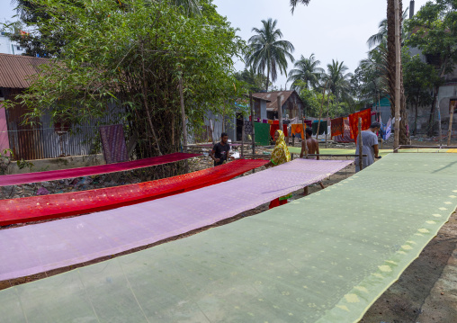 Bangladeshi workers putting wax on fabric, Dhaka Division, Rupganj, Bangladesh