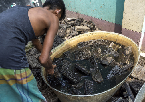 Bangladeshi man washing wooden block prints, Dhaka Division, Rupganj, Bangladesh