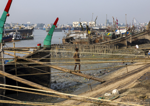 Bangladeshi man walking on pole to go in the fish market, Chittagong Division, Chittagong, Bangladesh