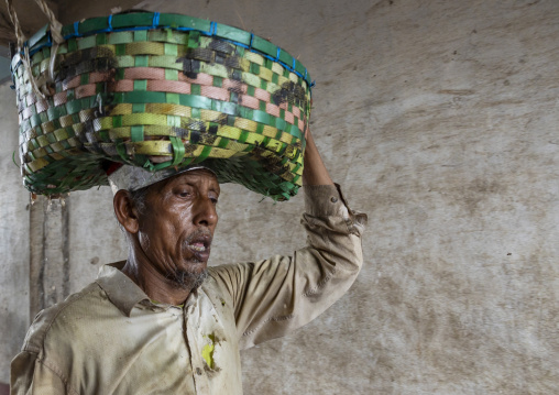 Bangladeshi man carrying a basket of fish on the head, Chittagong Division, Chittagong, Bangladesh