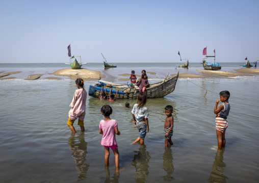 Bangladeshi children playing near moon fishing boats, Chittagong Division, Cox's Bazar Sadar, Bangladesh