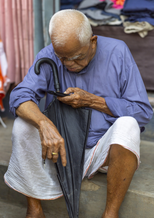 Chakma old tribe man reading his mobile phone, Chittagong Division, Rangamati Sadar, Bangladesh