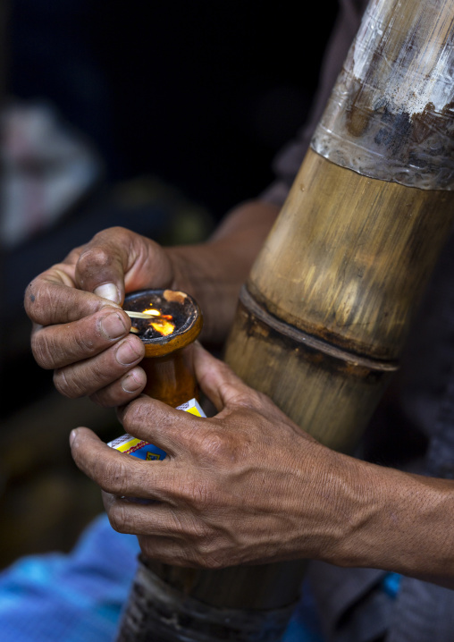 Chakma tribe man smoking bamboo pipe, Chittagong Division, Rangamati Sadar, Bangladesh