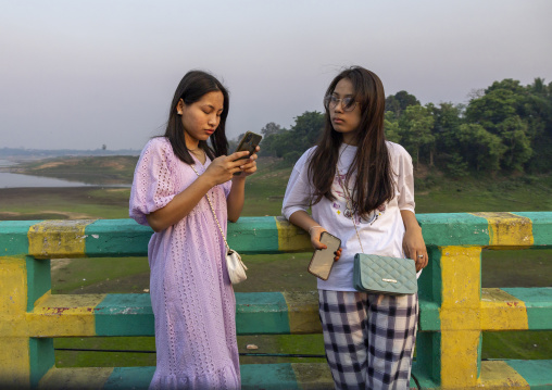 Bangladeshi young women texting on Brazil bridge, Chittagong Division, Rangamati Sadar, Bangladesh