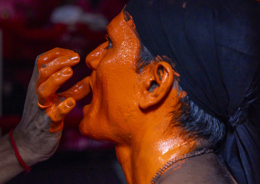 Make up of a Hindu devotee covered with orange color at Lal Kach festival, Dhaka Division, Munshiganj Sadar, Bangladesh