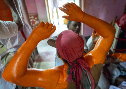 Make up of a Hindu devotee covered with orange color at Lal Kach festival, Dhaka Division, Munshiganj Sadar, Bangladesh