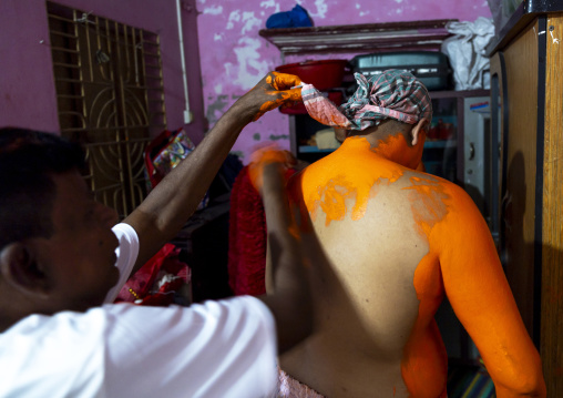 Make up of a Hindu devotee covered with orange color at Lal Kach festival, Dhaka Division, Munshiganj Sadar, Bangladesh