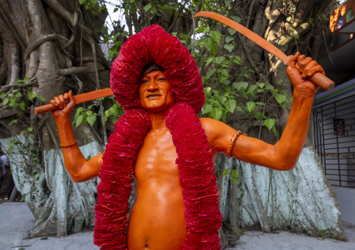 Hindu devotee with swords covered with orange color at Lal Kach festival, Dhaka Division, Munshiganj Sadar, Bangladesh