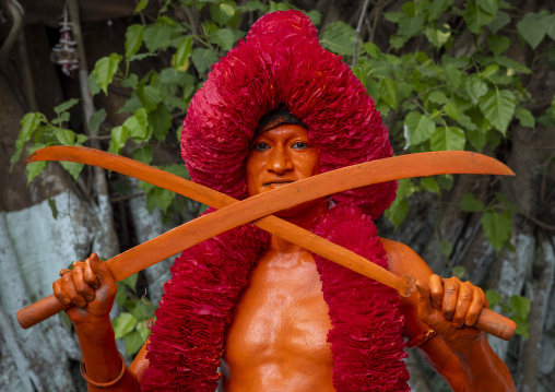 Hindu devotee with swords covered with orange color at Lal Kach festival, Dhaka Division, Munshiganj Sadar, Bangladesh