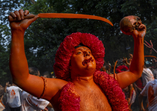 Hindu devotee with a sword covered with orange color at Lal Kach festival, Dhaka Division, Munshiganj Sadar, Bangladesh