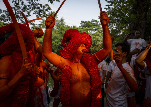 Hindu devotee with swords covered with orange color at Lal Kach festival, Dhaka Division, Munshiganj Sadar, Bangladesh