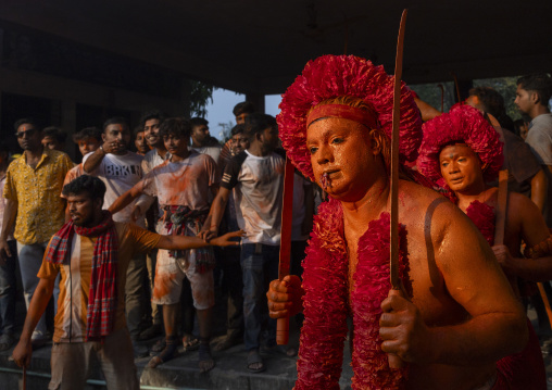 Hindu devotee with a sword covered with orange color at Lal Kach festival, Dhaka Division, Munshiganj Sadar, Bangladesh