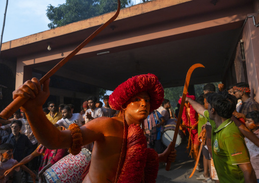 Hindu devotee with swords covered with orange color at Lal Kach festival, Dhaka Division, Munshiganj Sadar, Bangladesh