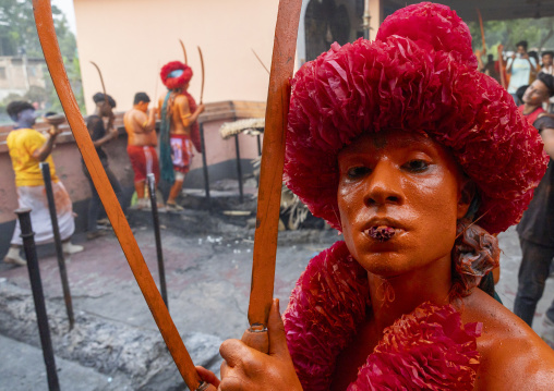 Hindu devotee with swords covered with orange color at Lal Kach festival, Dhaka Division, Munshiganj Sadar, Bangladesh