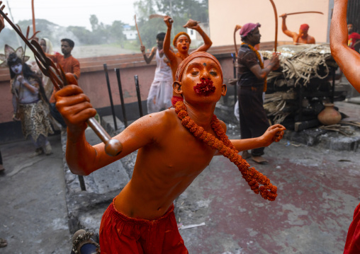 Hindu devotee with a sword covered with orange color at Lal Kach festival, Dhaka Division, Munshiganj Sadar, Bangladesh