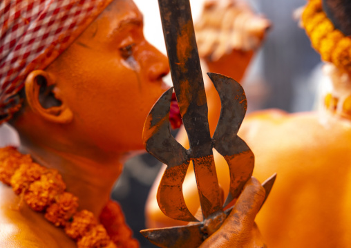 Hindu devotee with a sword covered with orange color at Lal Kach festival, Dhaka Division, Munshiganj Sadar, Bangladesh