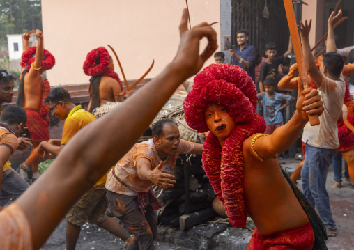 Hindu devotee with a sword covered with orange color at Lal Kach festival, Dhaka Division, Munshiganj Sadar, Bangladesh