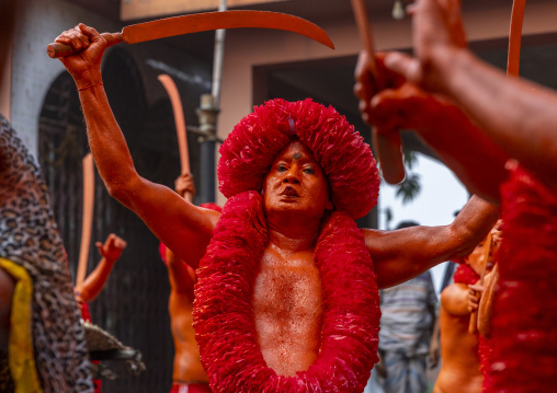 Hindu devotee with a sword covered with orange color at Lal Kach festival, Dhaka Division, Munshiganj Sadar, Bangladesh