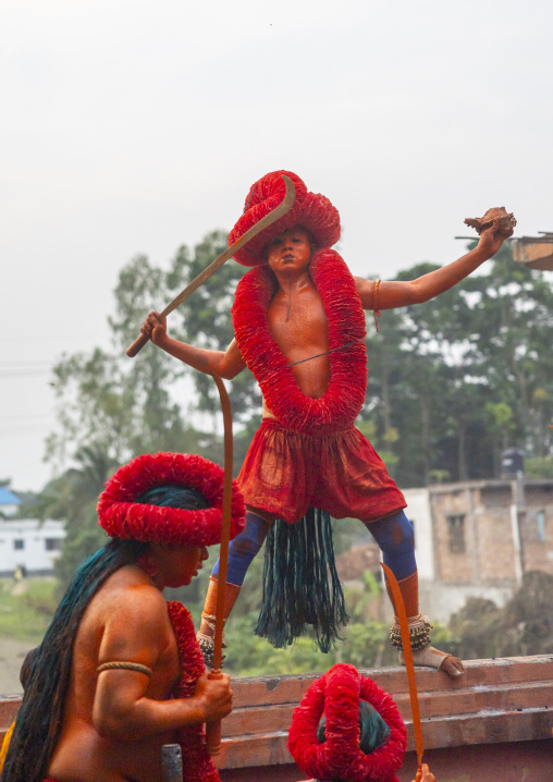 Hindu devotees covered with orange color dancing with swords at Lal Kach festival, Dhaka Division, Munshiganj Sadar, Bangladesh