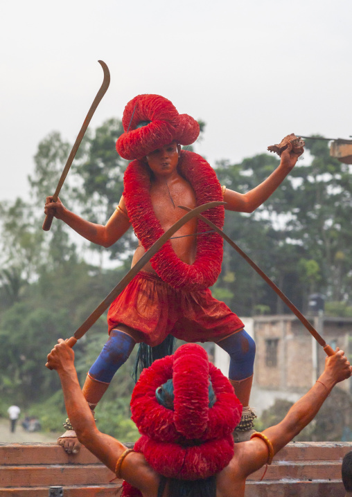 Hindu devotees covered with orange color dancing with swords at Lal Kach festival, Dhaka Division, Munshiganj Sadar, Bangladesh