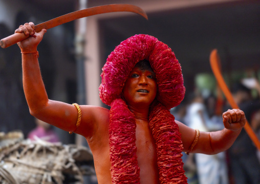 Hindu devotee with a sword covered with orange color at Lal Kach festival, Dhaka Division, Munshiganj Sadar, Bangladesh