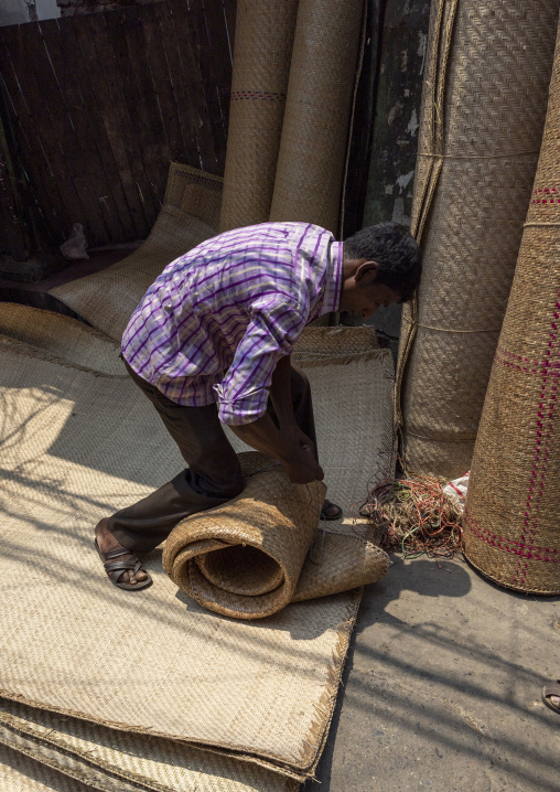 Bangladeshi man packing jute rugs in the street, Dhaka Division, Dhaka, Bangladesh