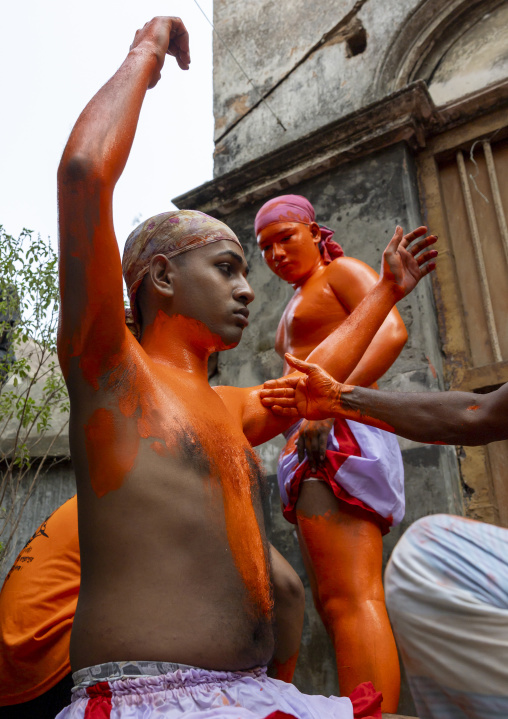 Make up of a Hindu devotee covered with orange color at Lal Kach festival, Dhaka Division, Munshiganj, Bangladesh