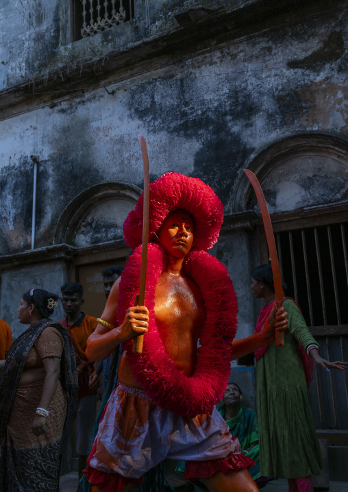 Hindu devotee with swords covered with orange color at Lal Kach festival, Dhaka Division, Munshiganj, Bangladesh